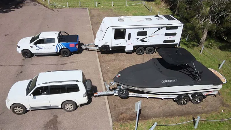 An aerial view of two Elecbrakes tow vehicles, one with a caravan and one with a boat