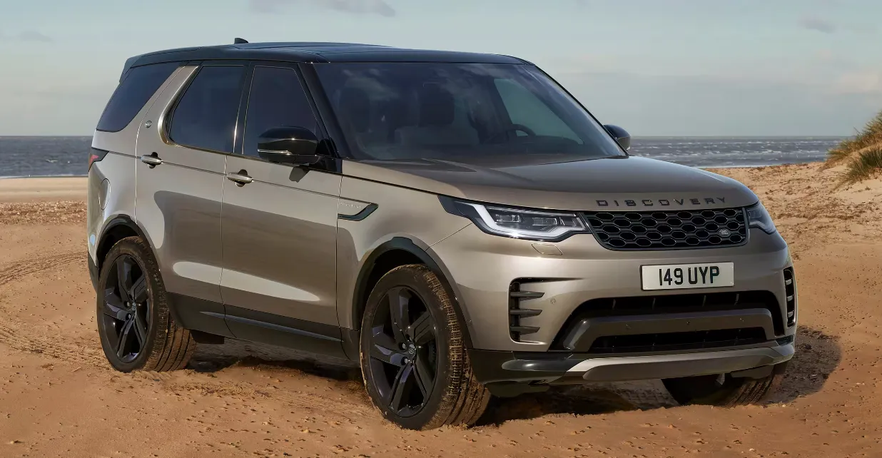 A bronze Land Rover Discovery parked on a beach