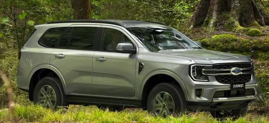 A silver Ford Everest parked in dense green bushland