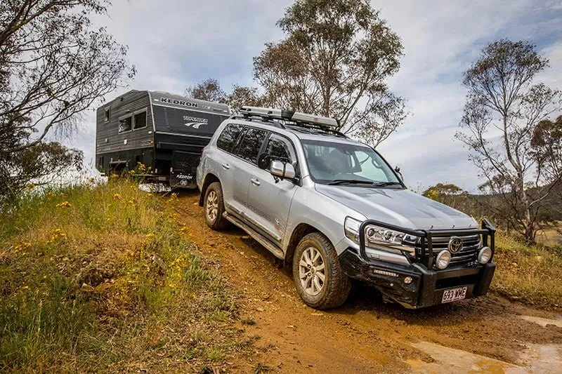 A Toyota LandCruiser towing a Kedron caravan up a steep dirt track
