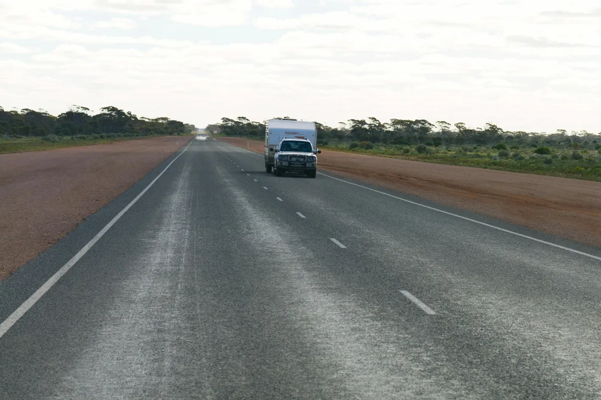 Car tows caravan on a wide Australian road