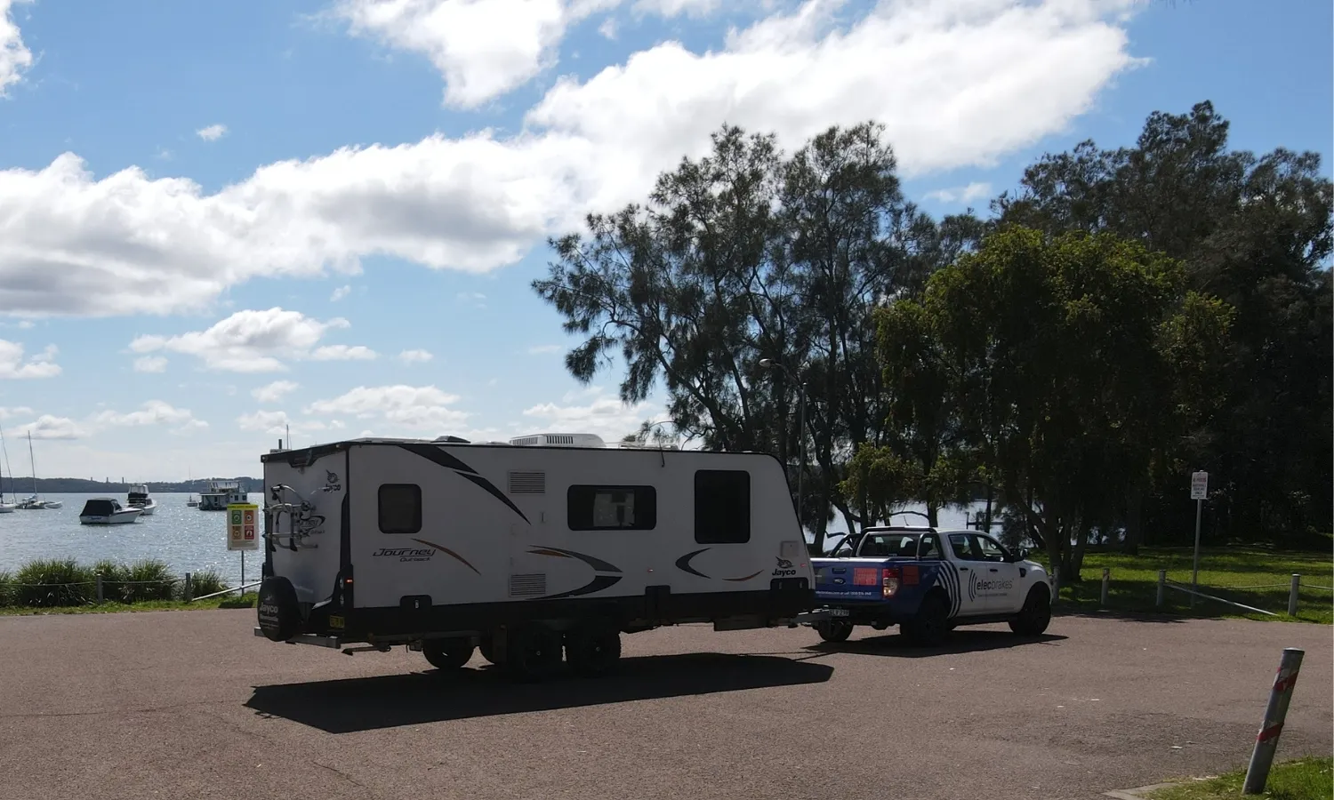 Tow vehicle pulling caravan near waterfront showcasing stable towing setup