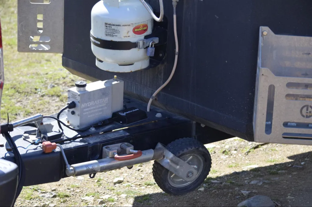 Caravan A-frame showing electric brake actuator and gas bottle setup