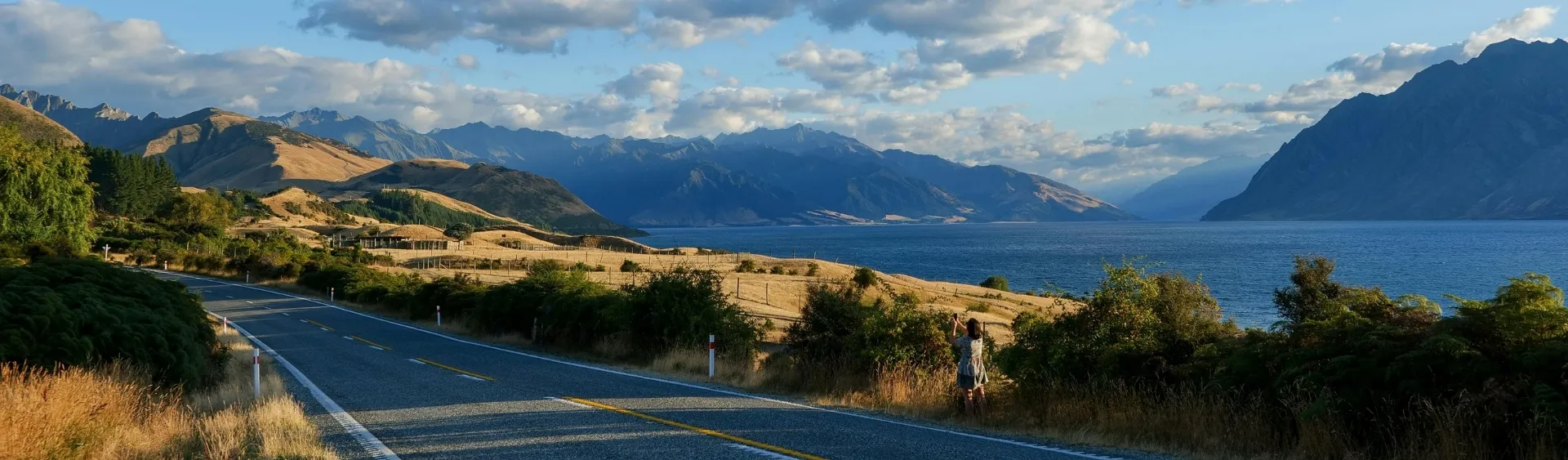 Scenic New Zealand highway beside an alpine lake and mountains, ideal for a caravan road trip
