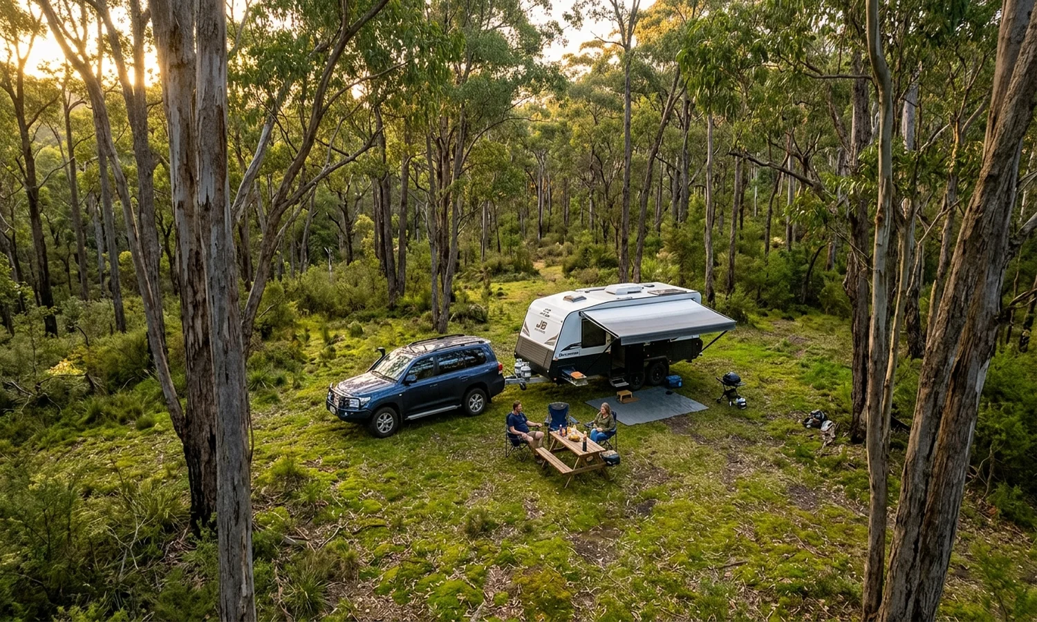 Caravan at a forest campsite surrounded by trees