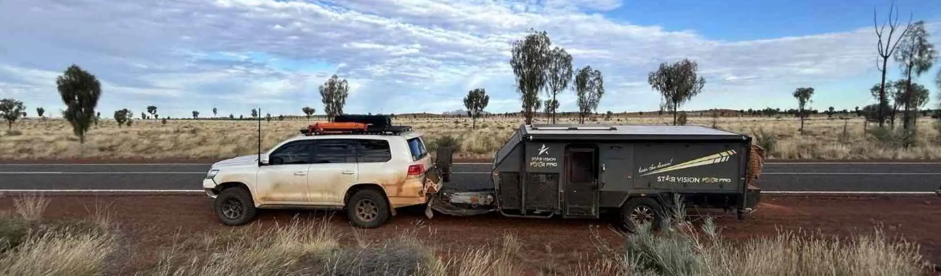 Caravan travelling along a remote sealed road through open landscape