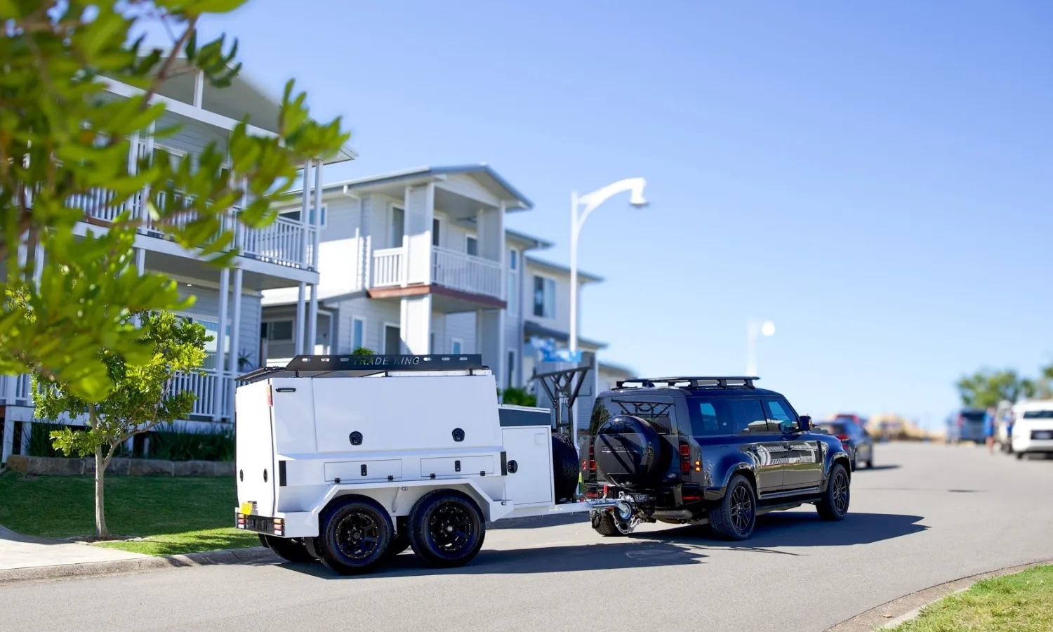 Car towing a trailer on a sealed road, demonstrating balanced braking during travel