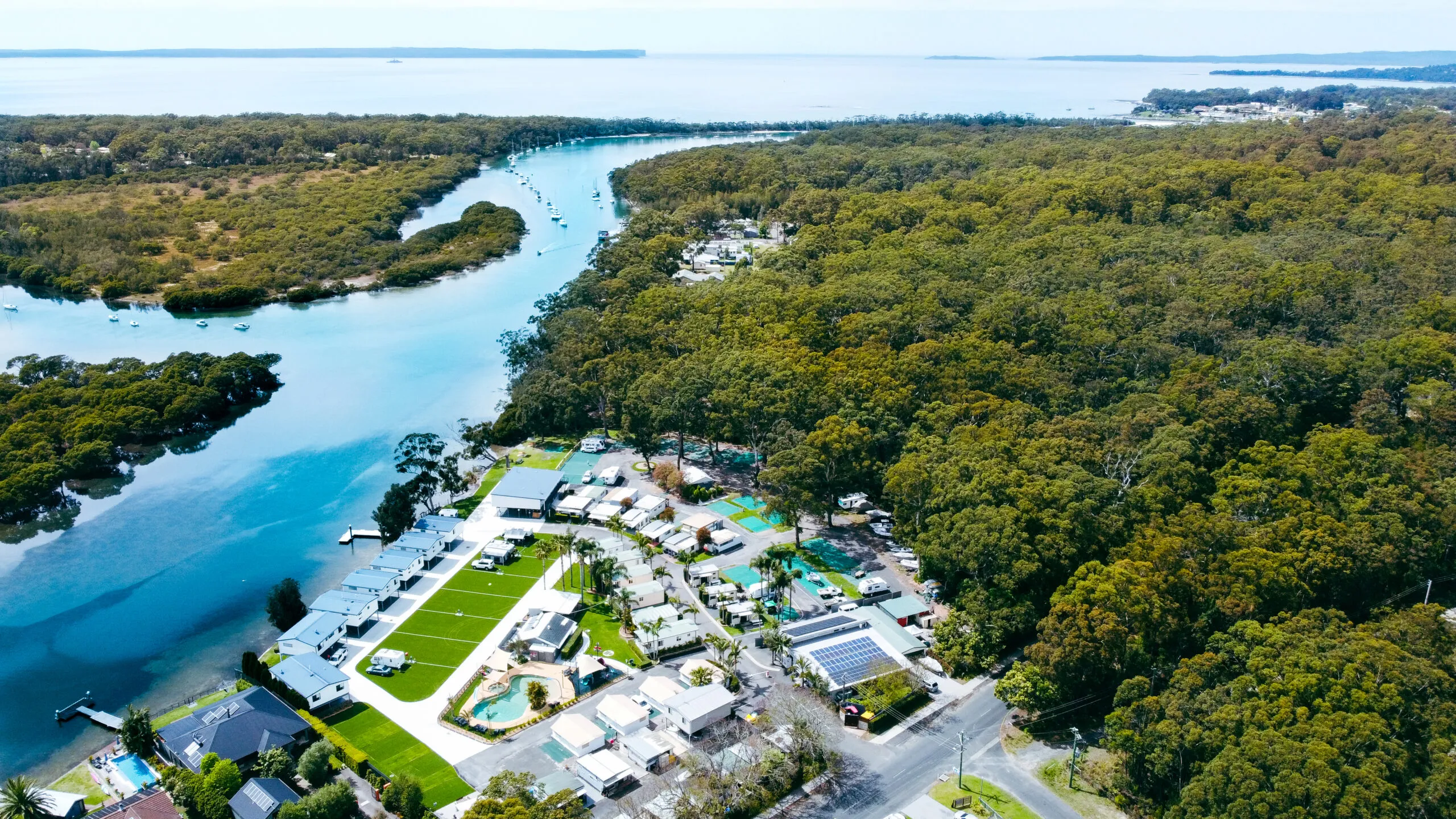 An aerial view of a waterfront caravan park on an inlet at Jervis Bay