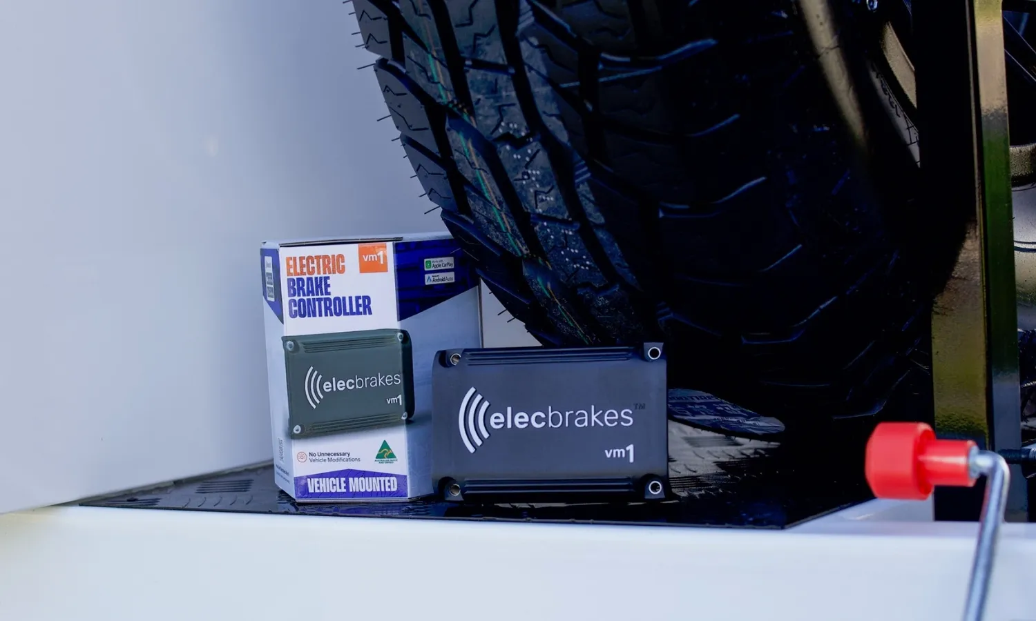 Elecbrakes VM1 brake controller and packaging on the ground beside a trailer wheel