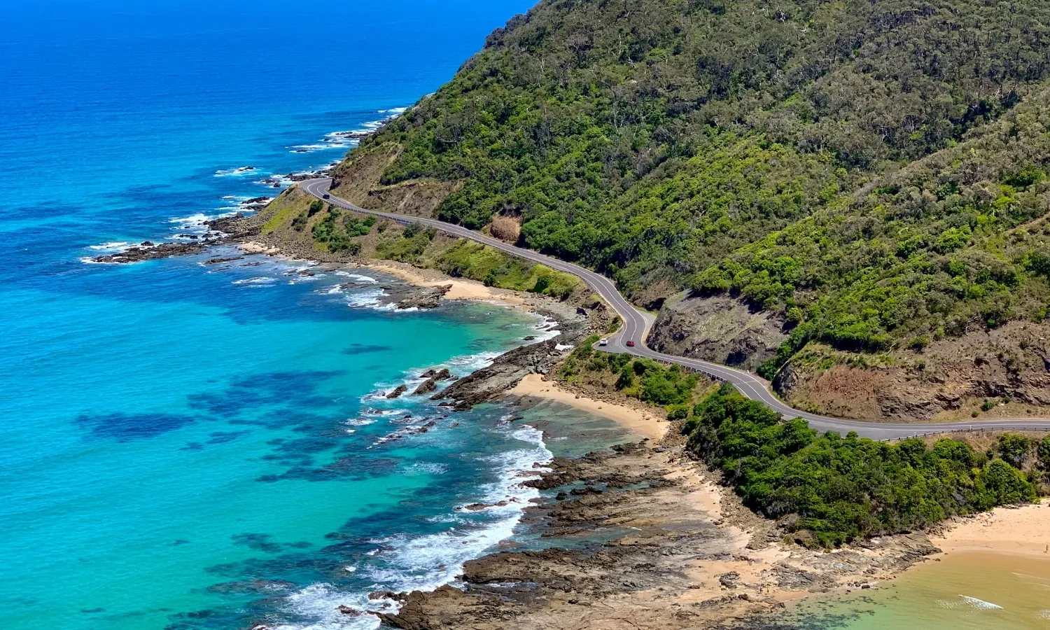 Aerial view of the Great Ocean Road with turquoise water, rugged cliffs and winding coastal highway