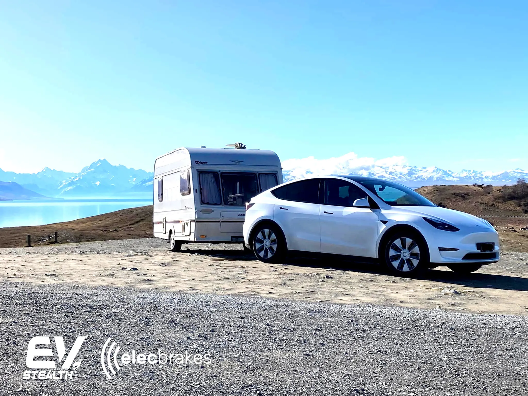 A white Tesla Model Y being towed on a flatbed tow truck, showcasing Elecbrakes towing equipment.