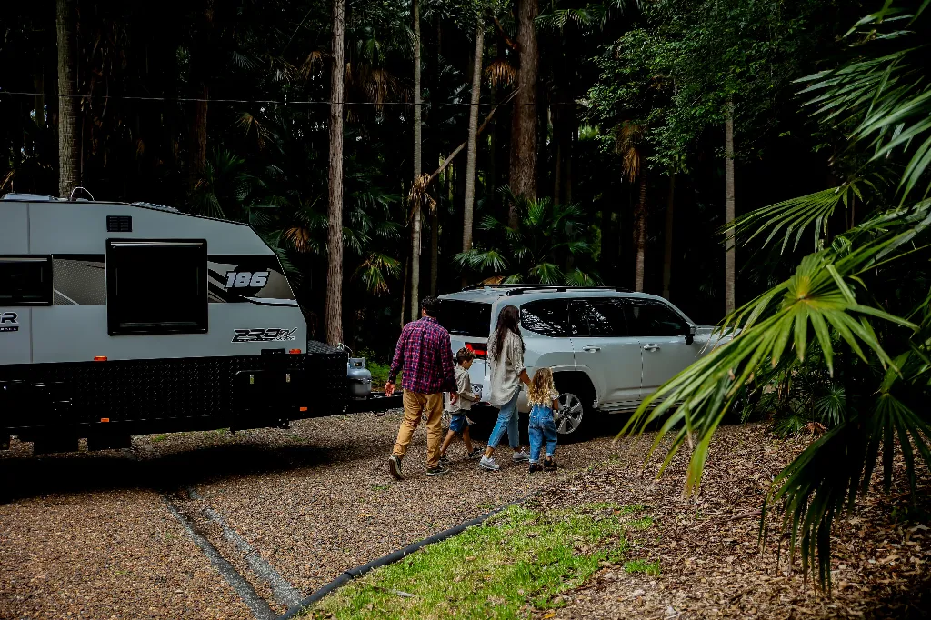 Family preparing to leave with their SUV and caravan for a long weekend towing trip