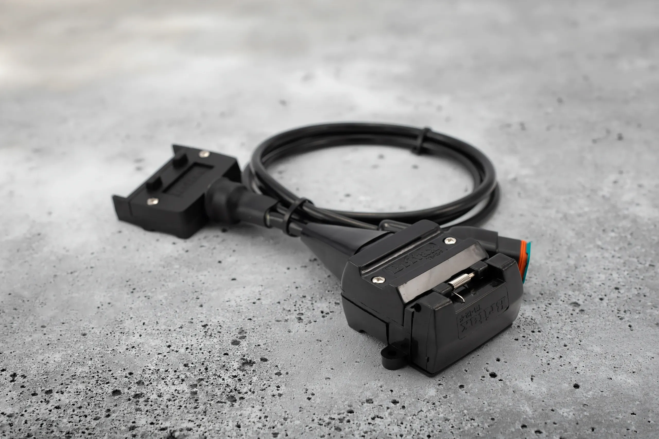An Elecbrakes wired plug and play adaptor on a concrete surface